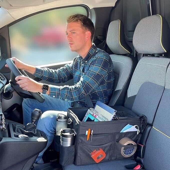 A tradesman driving a work van, using the myXplorer front seat organiser to keep important documents, tools, and work gear secure and organised.
